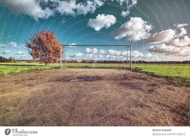 soccer goal with tree, skyline and cloudscape architecture autumn background ball berlin blue closeup competition empty europe fall field football game germany