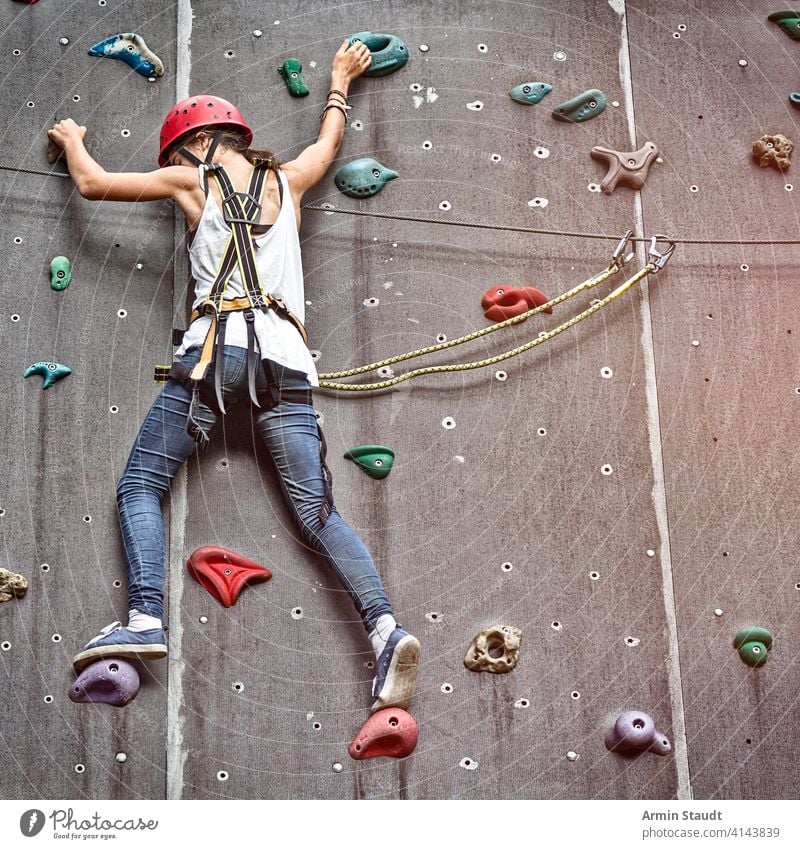 Teen Girl In A Free Climbing Wall active activity more adult Balance Bouldering ascent Climber tutorial Extreme Woman Fitness fun Hand Helmet hobby indoors