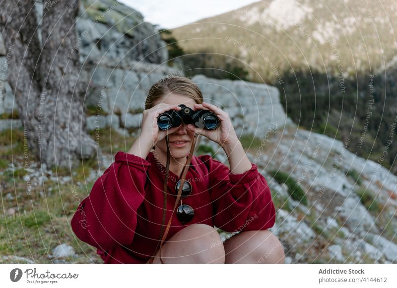 Female hiker with binoculars enjoying mountain landscape woman hill explore travel activity backpacker nature discovery forest trekking young adventure spain