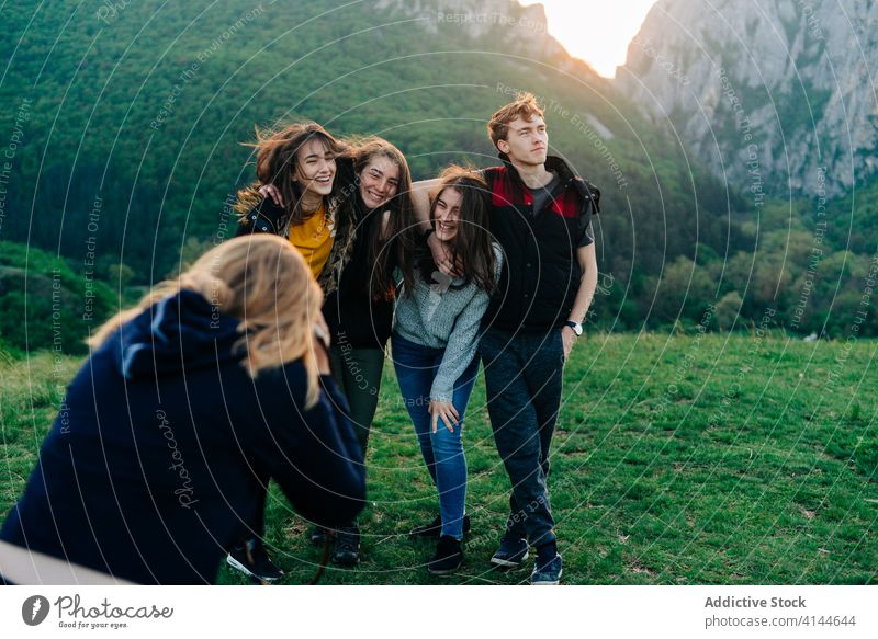 Woman taking photo of friends in mountains vacation together unity company highland take photo travel moment transylvania romania saint george group happy green