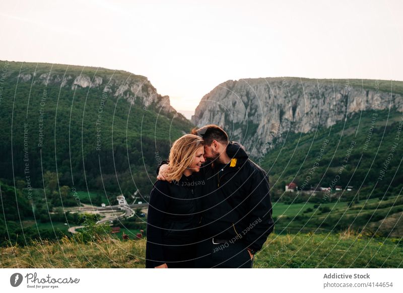 Traveling couple hugging in highlands vacation enjoy sunset together mountain range holiday transylvania romania saint george tourism embrace love happy