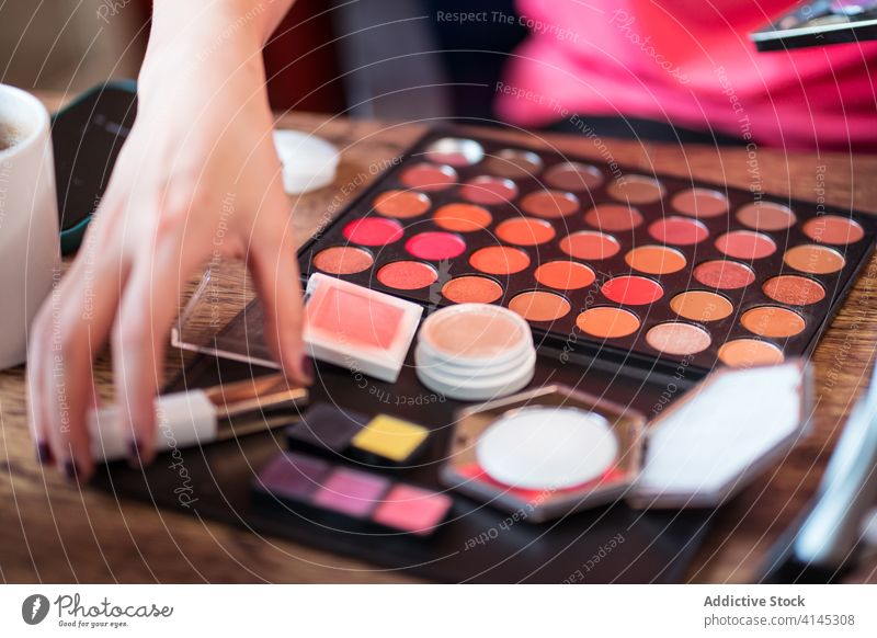 Anonymous female blogger applying makeup beauty woman palette cosmetic vlog brush record video colorful eyeshadow blush mirror film fashion style modern glamour