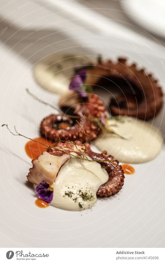 Octopus tentacles with cream sauce octopus plate dish restaurant serve petal haute cuisine delicious palatable portion yummy flower tasty food delectable meal