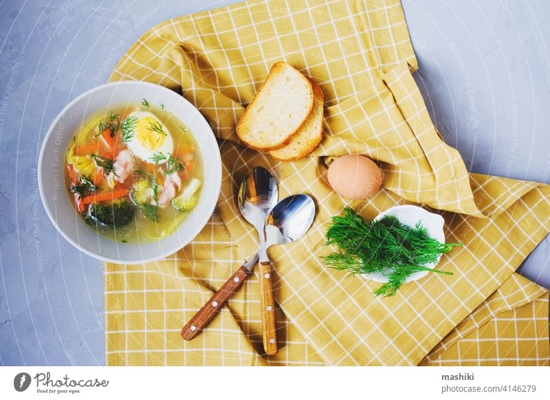 healthy homemade chicken noodle soup with egg, broccoli and carrot served in plate with toasted bread vegetable dinner food lunch meal meat bowl pasta delicious