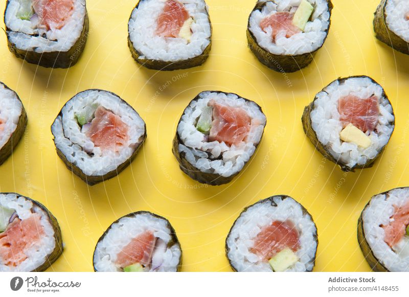 Appetizing sushi rolls on yellow background studio salmon rice delicious asian food tasty tradition japanese meal table cuisine dish fresh gourmet seafood
