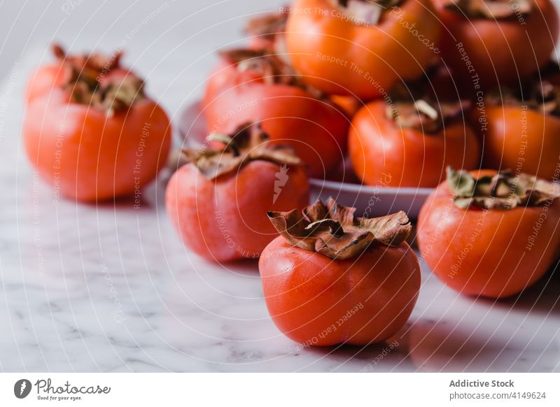 Ripe persimmons on plate in kitchen fruit sweet pile fresh vitamin diet nutrition nutrient delicious bright table healthy heap natural food healthy food organic