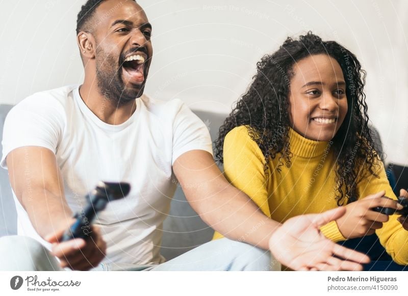 Happy young man playing and winning online game on computer. Back view of  gamer with video console gamepad controller. Competitive gaming, electronic  sports, technology, gaming, entertainment concept., Stock image