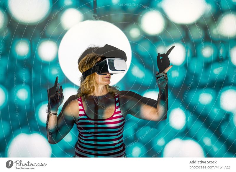 Woman in VR goggles exploring virtual reality woman vr headset touch experience explore illuminate projector technology innovation gadget entertain digital