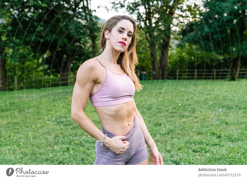 Fit woman in sportswear standing in park fit slim sporty active fitness training portrait workout confident exercise young sportswoman athlete lifestyle female