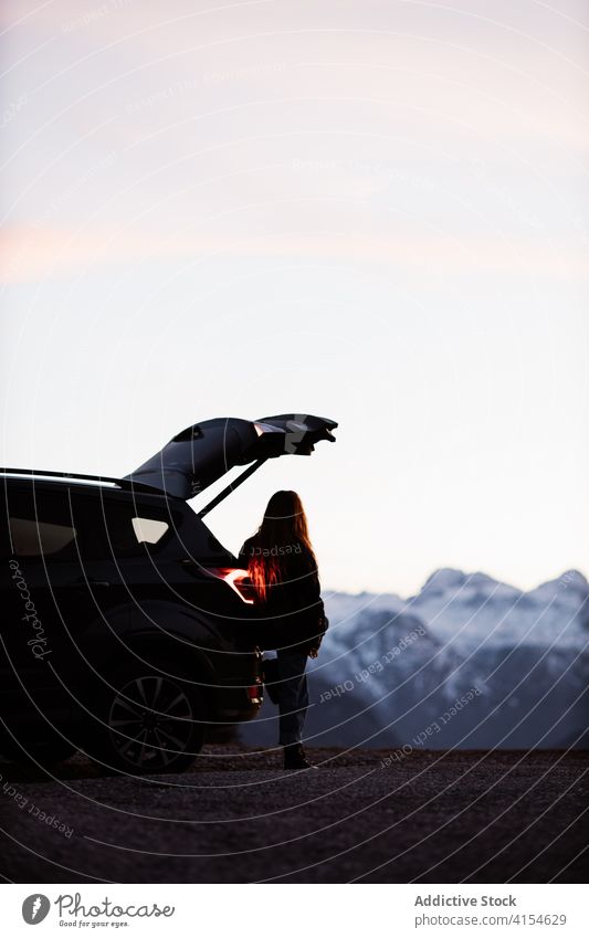 Lonely woman near car in highlands travel mountain admire evening relax peaceful automobile female germany austria scenery twilight dusk modern trip journey