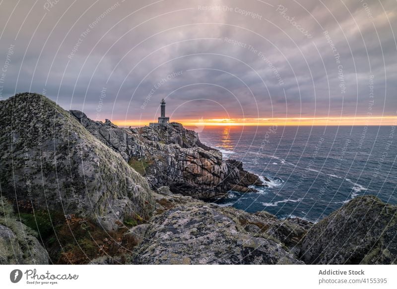 Beacon on rocky hill at sunset lighthouse cliff scenery beacon sundown sky sea rough spectacular coast dusk evening scenic breathtaking twilight water ocean