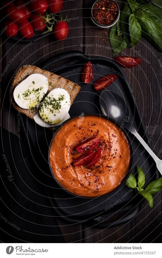 Appetizing tomato soup in bowl on table delicious dinner toast vegetable garnish basil appetizing tray thick dish cuisine yummy delectable serve portion food