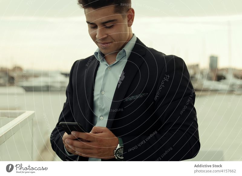 Cheerful businessman on mobile phone in city entrepreneur smartphone text content formal suit using male manager device executive job modern smile professional