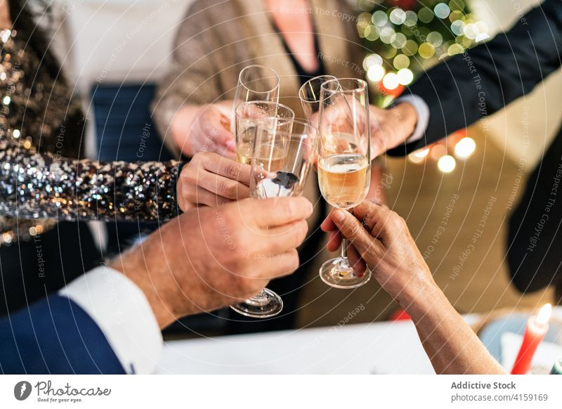 Company of people celebrating Christmas together christmas party home celebrate clink glass company cheers champagne beverage toast gather event occasion group