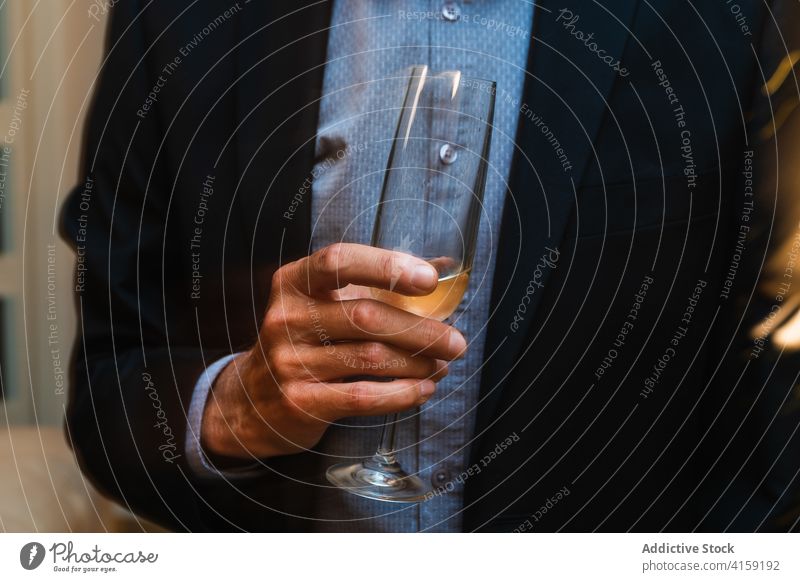 Crop man in suit with glass of champagne party christmas elegant celebrate costume festive male drink tradition alcohol holiday beverage sparkle winter event