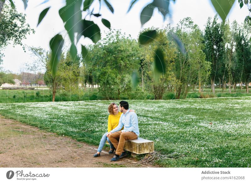 Couple in love sitting on bench in park couple hug together embrace summer relax enjoy weekend girlfriend boyfriend date tender romantic fondness bonding happy