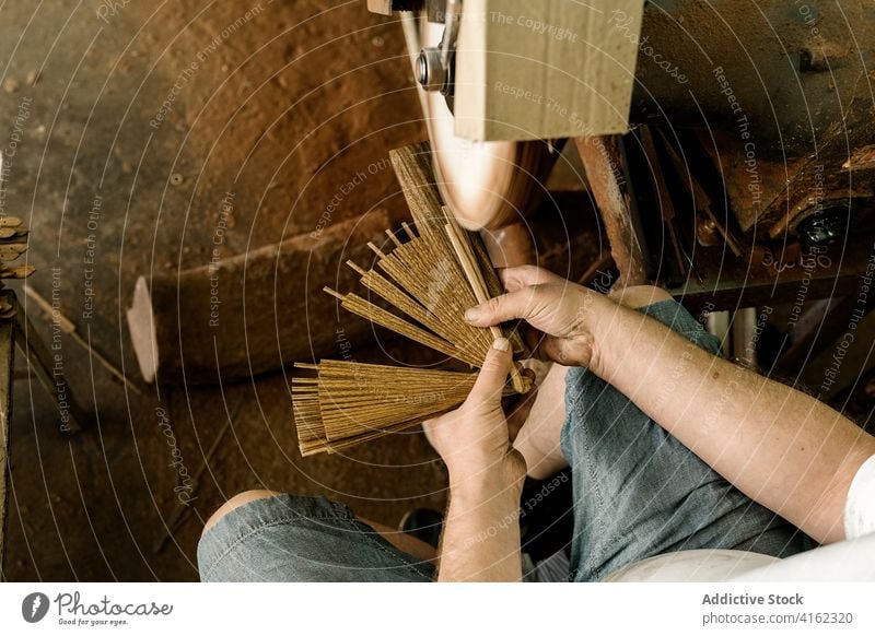 Crop woodworker grinding details in workshop man carpentry folding fan create handicraft machine male craftsman occupation creative wooden job equipment shabby