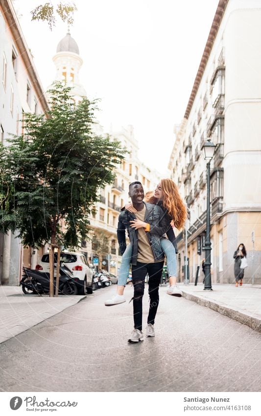 Lovely Multiethnic Young Couple walking playing having fun street front view portrait relationship multi-racial black man caucasian multi-cultural multi-ethnic