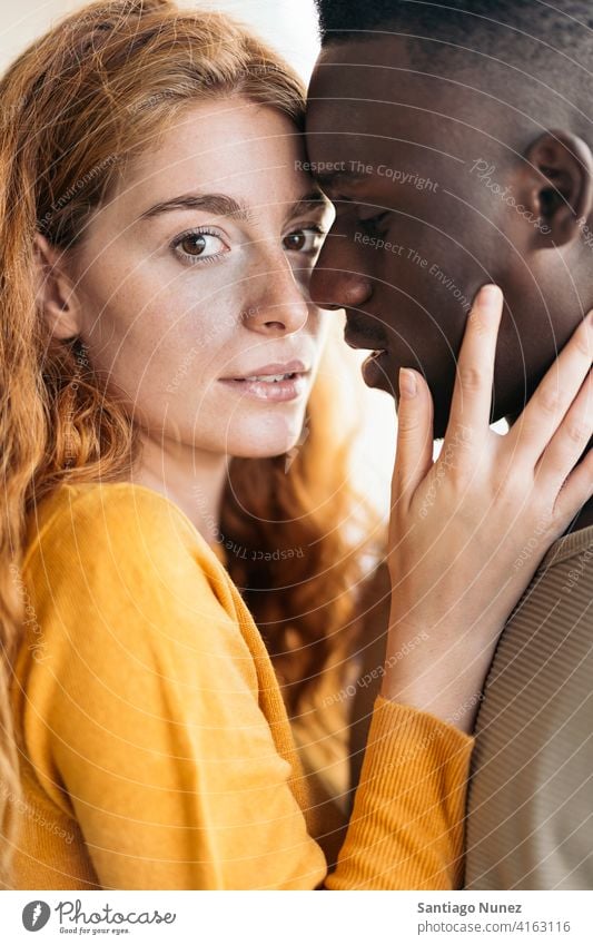 Loving Multiethnic Couple Closeup closeup looking at each other kissing portrait front view standing relationship multi-racial black man caucasian