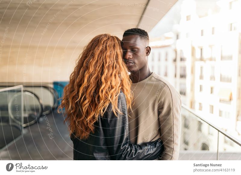 Loving Multiethnic Couple Portrait looking at each other portrait front view hugging standing relationship multi-racial black man caucasian multi-cultural