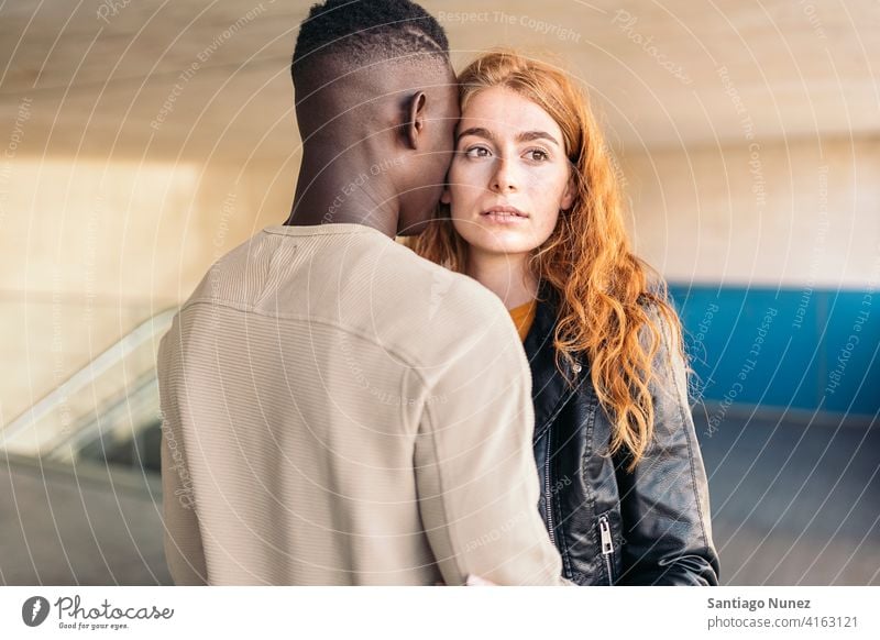 Loving Multiethnic Couple Hugging looking at each other portrait front view hugging standing relationship multi-racial black man caucasian multi-cultural