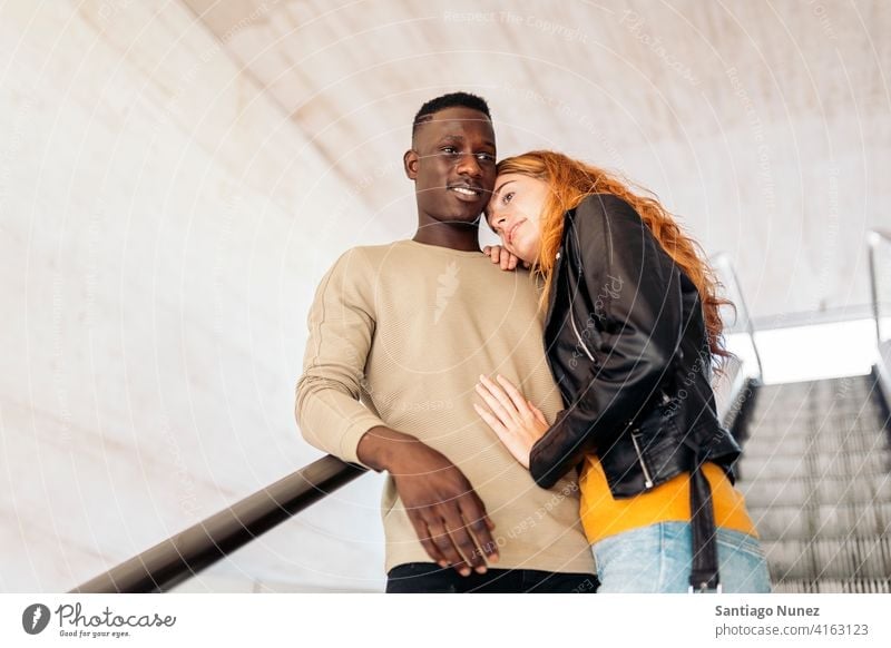Loving Multiethnic Couple Portrait stairs smiling hugging looking at each other portrait front view standing relationship multi-racial black man caucasian