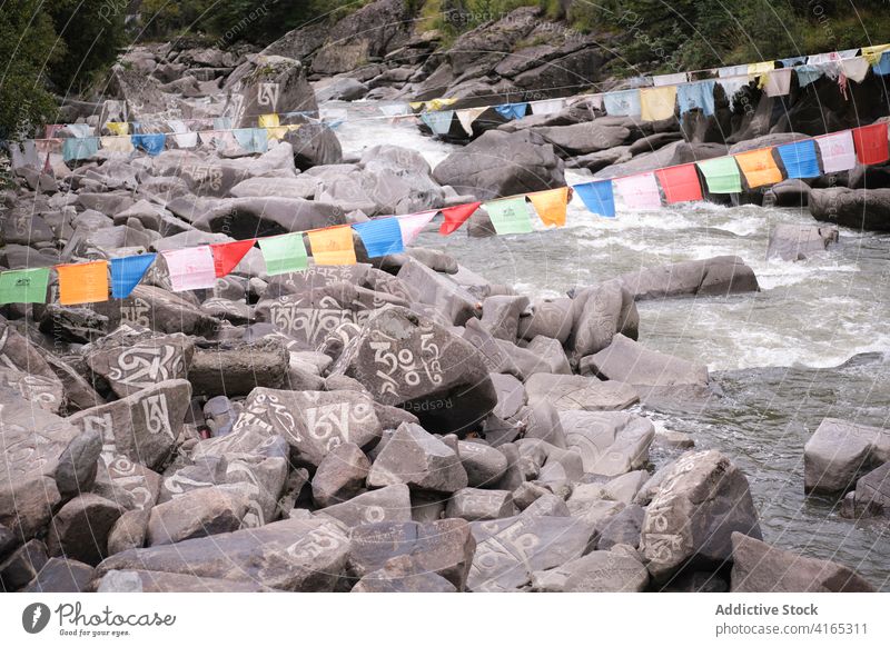 Sanskrit mantra on stones in river om mani padme hum religion stream flow landscape terrain faith nature rocky scenic water travel village china baiyu valley