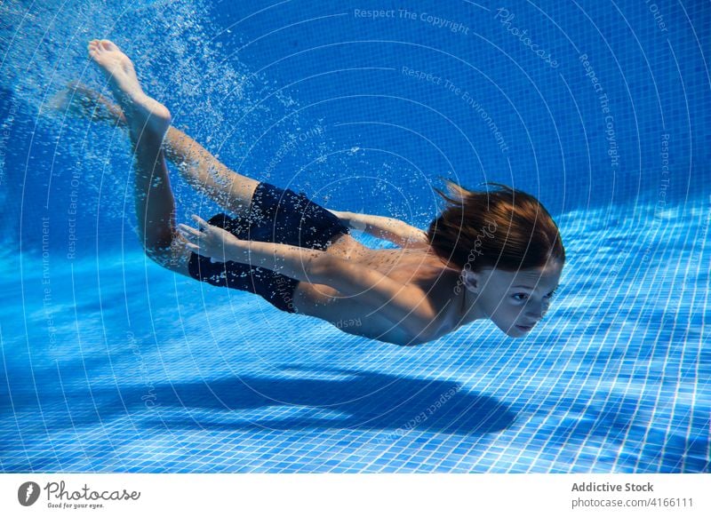Teenage boy diving into pool water teenage energy dive swim active underwater activity carefree playful splash aqua resort plunge enjoy relax delight bubble