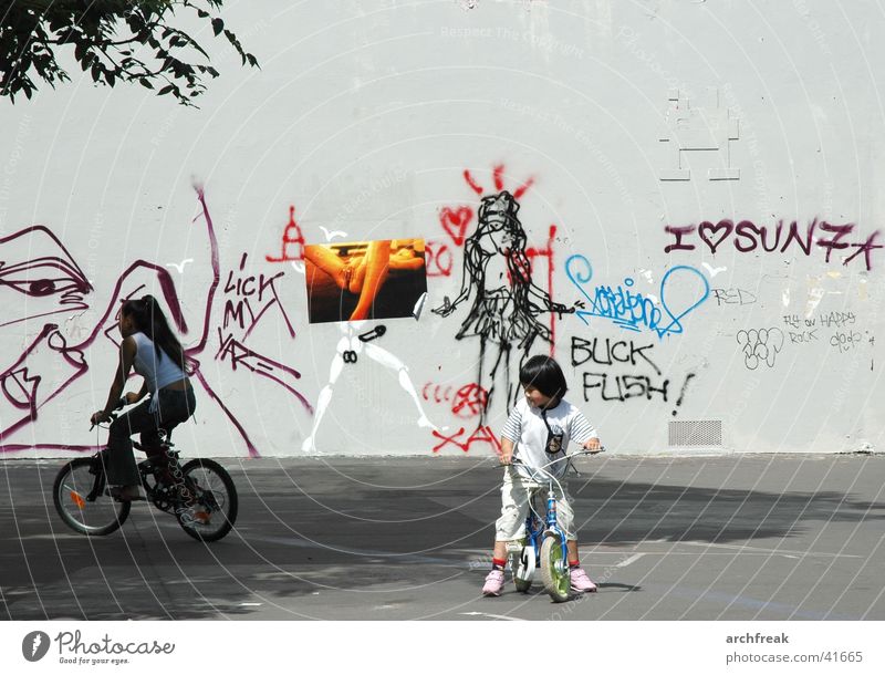 Fantasies in the city Child Girl Bicycle Places Wall (building) Woman Human being Scooter Graffiti Cycling Playing Effortless Exterior shot