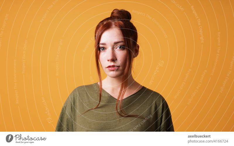 portrait of pretty young woman with red hair bun and curtain bangs person girl redhead red-haired beauty adult beautiful serious face model female caucasian