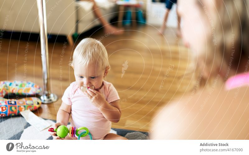 Cheerful mother and baby girl playing on floor woman home happy having fun toy grimace love daughter together adorable young child toddler motherhood cute joy