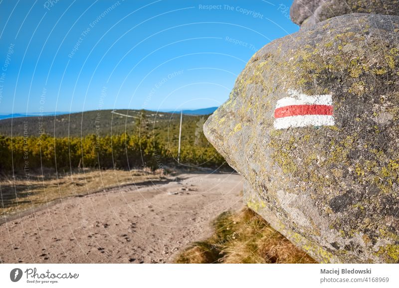Red hiking mountain trail marker painted on a rock, selective focus, Karkonosze National Park, Poland. marking nature forest adventure path mountains landscape
