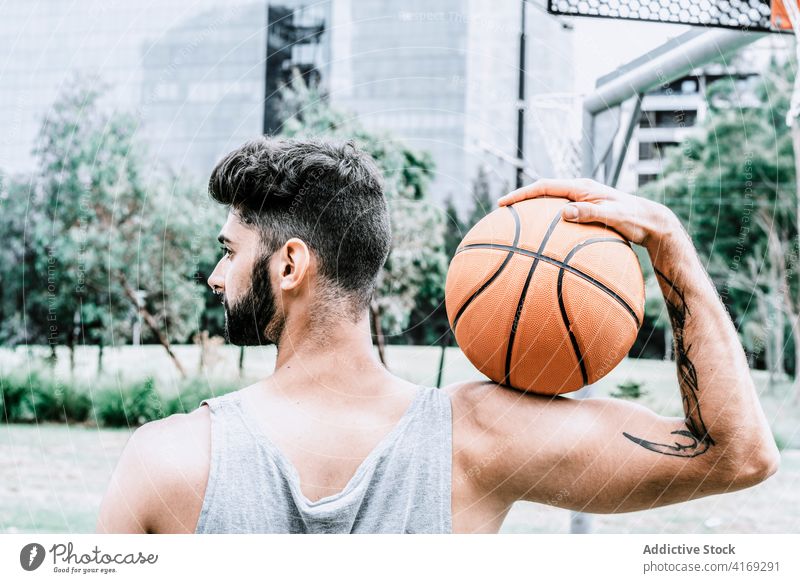 Sporty man with basketball ball on street player confident sporty beard game streetball male young tattoo muscular athlete urban activity training hobby