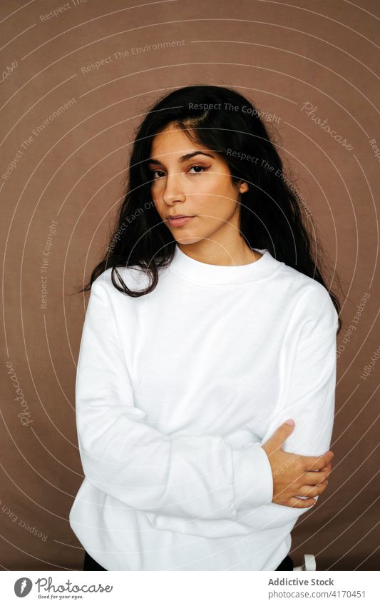 Woman in stylish clothing in studio trendy outfit woman confident style apparel model long hair appearance female ethnic chair lean calm stand peaceful fashion