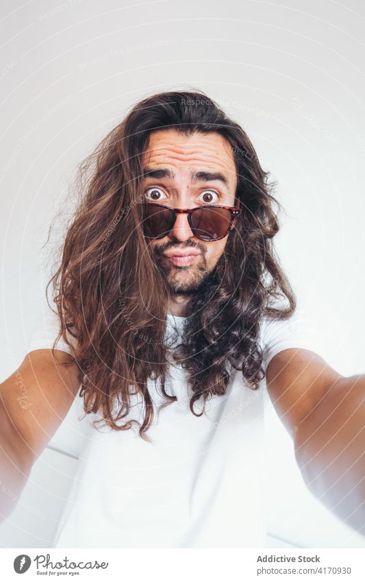 Hipster man with funny surprised face looking at camera amazed hipster long hair beard sunglasses human face expressive selfie young male grimace unbelievable