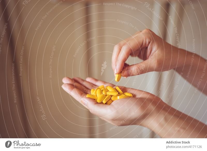 Anonymous person showing yellow pills hand vitamin health care medical supplement demonstrate treat medicine drug therapy product medication colorful wellness