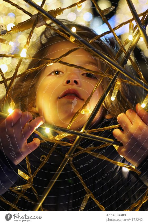 trapped in the light Child Girl portrait Winter Face Captured Light Illuminate LED light chain Fairy lights Christmas & Advent Christmas Fair winter jacket Cold