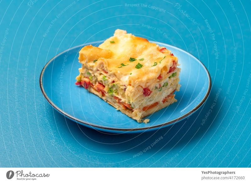 Vegetarian lasagna on a blue plate. Single portion of lasagna background baked bechamel sauce cheese close-up cooked copy space cuisine cut out delicious dinner