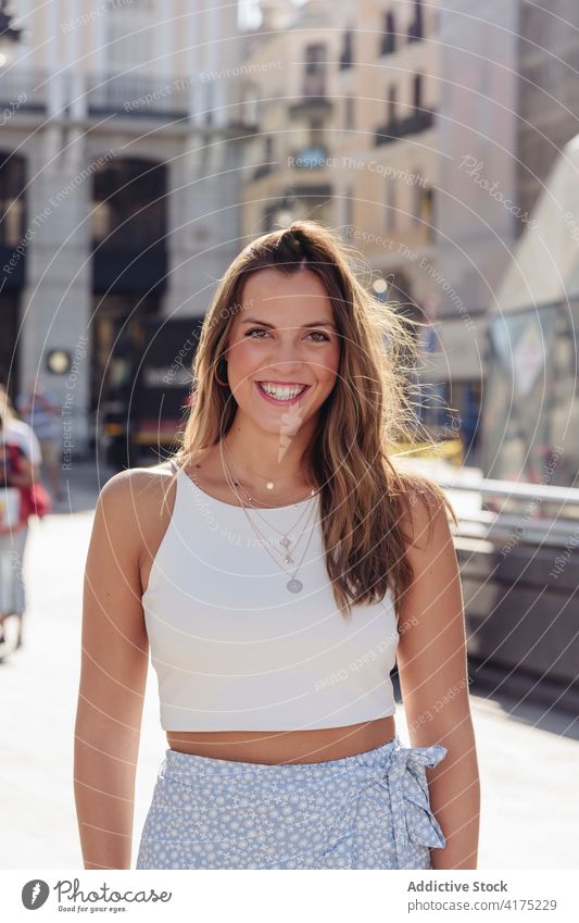 Stylish young woman standing on street style urban smile summer trendy long hair millennial positive charming female happy cheerful lifestyle optimist lady