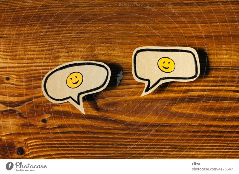 Two speech bubbles with laughing smileys. Positive conversations and communication. Speech bubble Friendship two talk Communicate kind Laughter Smileys Joy
