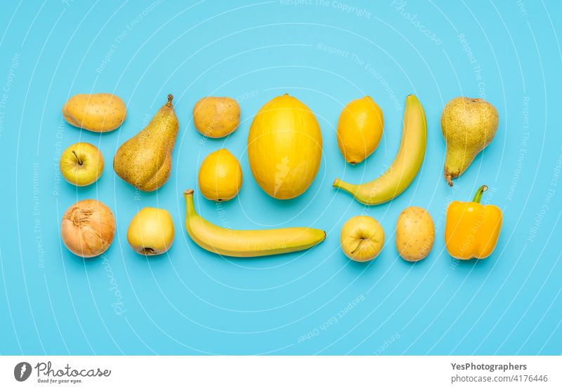 Yellow fruits and vegetables isolated on a blue background. above aligned apple banana bright citrus collection colorful colors copy space creative cut out