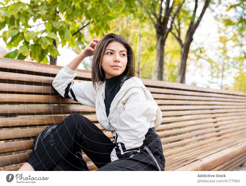 Ethnic woman relaxing on bench in park pensive dream thoughtful rest tranquil young dreamy latin ethnic female lifestyle calm serene contemplate ponder trendy