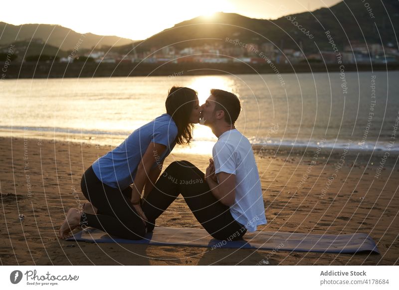 Couple doing yoga and kissing at seaside couple together practice love beach asana pose activewear nature harmony relationship soulmate summer tender romantic