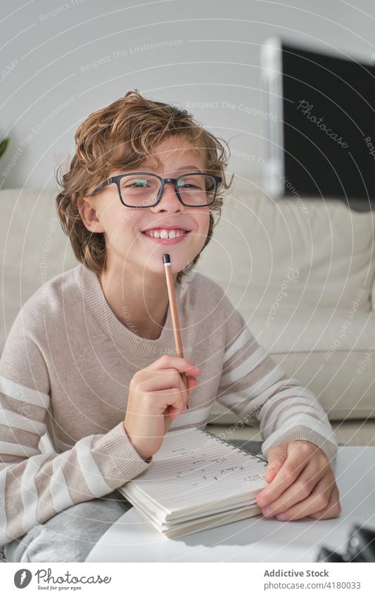 Expressive Boy Portrait portrait young boy looking at camera expressive expression at home cozy writing taking notes cheerful glasses think thoughts smile