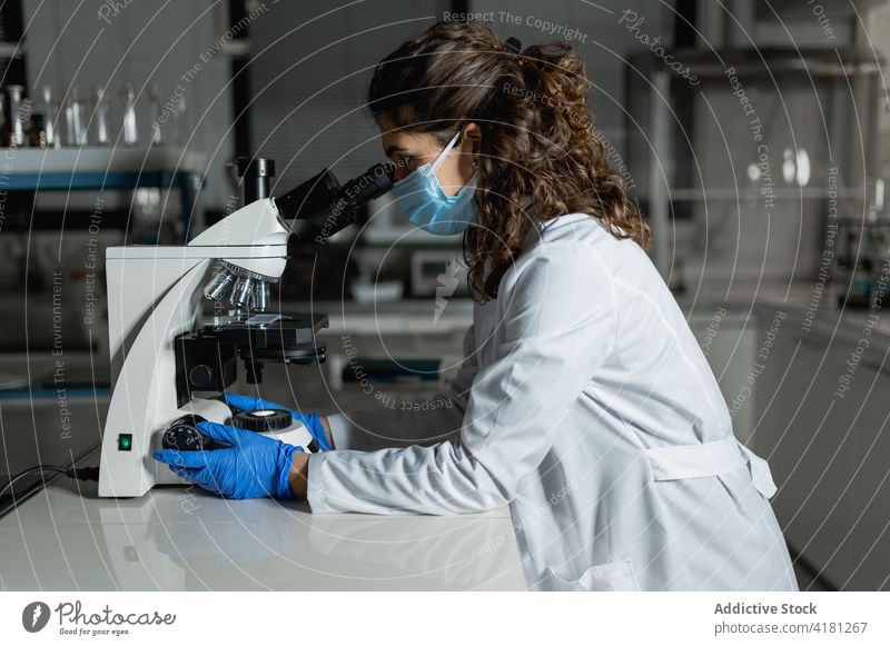 Researcher working with microscope in biotechnology laboratory scientist experiment research examine equipment analyze chemical woman investigate analysis