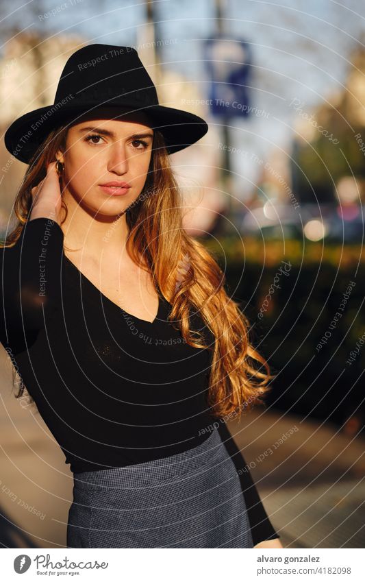 Outdoor full-length fashion portrait of young confident woman