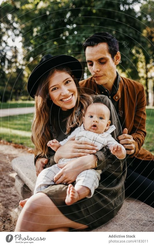 Happy family with baby resting in park together love happy parent relationship bonding care infant child mother father kid parenthood childhood mom enjoy