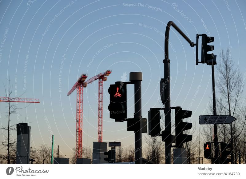Traffic lights and construction cranes in the light of the setting sun on Hanauer Landstraße in the Ostend district of Frankfurt am Main in the German state of Hesse