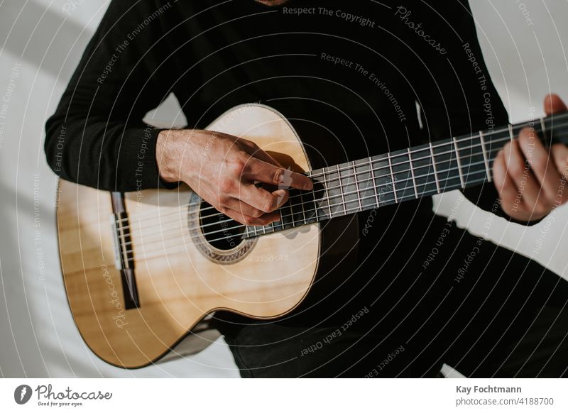 photo of man playing classical guitar acoustic adult arm artist chords closeup expertise fingers flamenco fretboard guitar player guitarist guitarists guitars