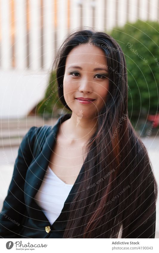 Asian businesswoman walking in street in downtown city entrepreneur megapolis well dressed style female asian ethnic urban modern elegant skyscraper building